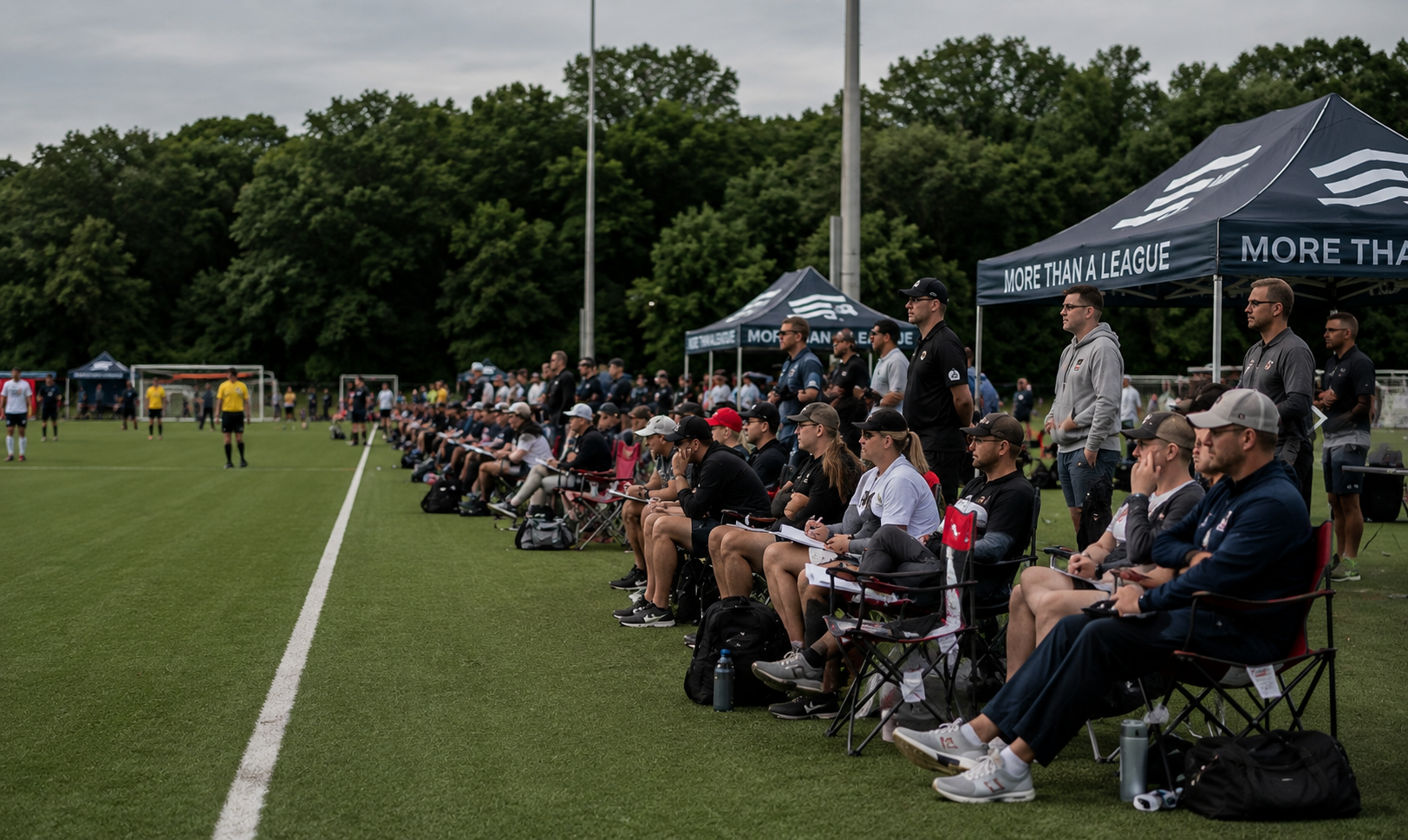 College coaches watching from the sideline at a soccer showcase